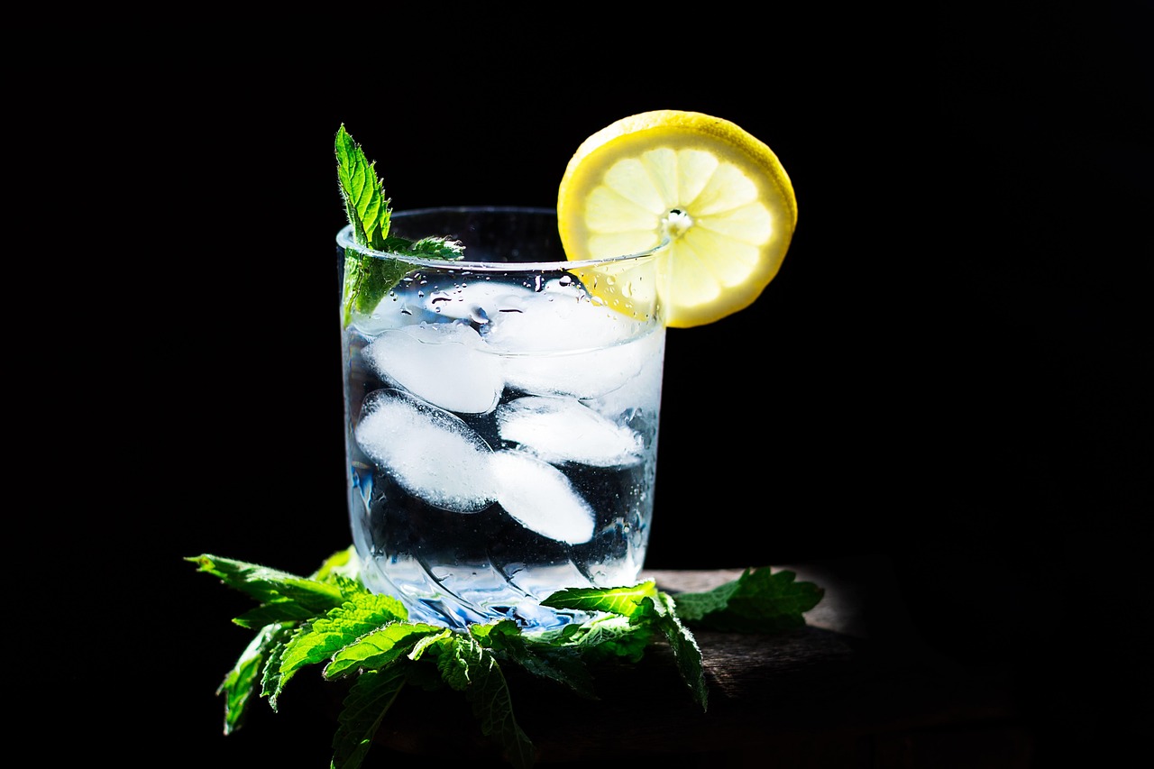 Uomo che beve un bicchiere d'acqua fredda dopo un pasto, con espressione di sorpresa.