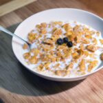 Ciotola di cereali con latte e frutta fresca, ideale per una colazione sana e nutriente.