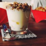 Yogurt fresco in una ciotola con cucchiaio, simbolo di benefici per l'intestino.